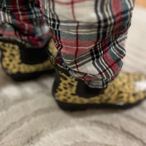 Leopardmönstrade stövlar - Snygga leopardmönstrade stövlar med svarta detaljer. Perfekta för att ge en djärv touch till din outfit. De har en robust sula och är idealiska för regniga dagar.