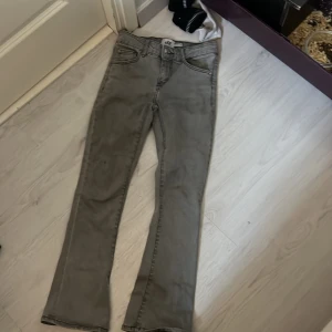 Grå jeansbyxor från 157 - Snygga grå jeansbyxor från 157 med en skön flare-stil. De har en klassisk femficksdesign och en knappgylf. Perfekta för en avslappnad look.