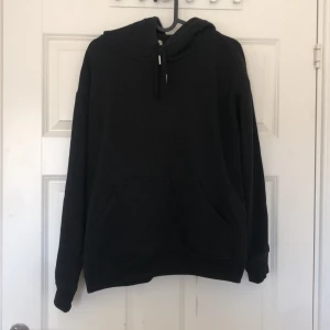 Svart hoodie - Säljer en klassisk svart hoodie med justerbar huva och känguruficka framtill. Perfekt för en avslappnad stil och passar till det mesta. Skön och enkel att bära. Den är i storlek S men passar även mig som är M🥰🥰