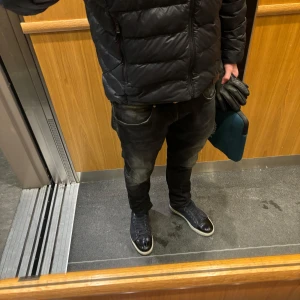 Dondup George  - Snygga svarta dondup med diskreta slitningar och en klassisk femficksdesign. Byxorna har en normal passform och är perfekta för en avslappnad stil. 