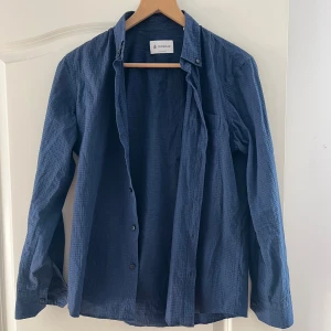 Blå Dondup skjorta - Detta är en blå Dondup skjorta som jag säljer för att jag inte använder den. Den är köpt i en Dondup affär i Italien, storleken är S. Den har kort kropp och långa armar. Hör av dig vid intresse!