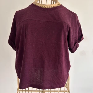 Lila kortärmad topp från Divided - Säljer en lila kortärmad topp från Divided i bomull/polyester. Toppen har en avslappnad passform med korta ärmar och lite kortare i midjan . Stl xs och i mycket bra skick. Perfekt för en casual look.