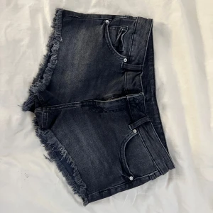 Lågmidjade shorts från h&m  - Snygga svarta lågmidjade jeansshorts från H&M Divided med fransiga kanter. Använda ett fåtal gånger. Pris kan förhandlas!
