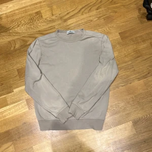 Stone Island tröja - Beige stone island tröja. Hel och fräsch men tyvärr saknas märket på ärmen. Knappar finns 