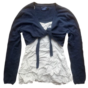 Mörkblå vintage bolerotopp från Mexx - Säljer en snygg mörkblå bolerotopp från Mexx. Toppen har långa ärmar och knytning framtill. Strl L men passar S-M mera. (Vita toppen under är inte inkluderad)