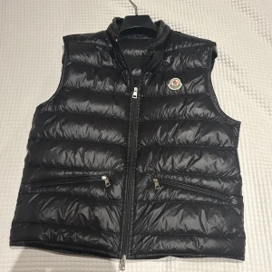 Svart dunväst från Moncler - Snygg svart dunväst från Moncle. Originalpris: 9200kr. Perfekt för kyligare dagar och kan användas vardaglig och till lite finare tillfällen. MoncleTillbehör mm finns tillgängligt. Priset är förhandlingsbart 😜👍🏻. 