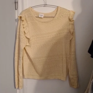 Beigel stickad tröja från Stories - Säljer en söt beige stickad tröja från Stories med volangdetaljer på axlarna. Tröjan har ett fint mönster och långa ärmar, perfekt för vår och sommar. Passar bra till både jeans och kjol. Tips! Kan vara bra med ett linne under då den är lite genomskinlig. Pris kan diskuteras 🌼 