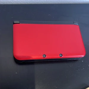 Röd Nintendo 3DS XL - Säljer en röd Nintendo 3DS XL. Den har en stor skärm och klassiska kontroller för en fantastisk spelupplevelse. Fungerar dock inte, vattenskada, men går säkert att lösa om man är teknisk.