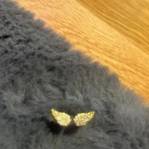 Guldpläterad ring med glittriga detaljer - Elegant guldpläterad ring med två glittriga detaljer som liknar vingar. Perfekt för att ge en touch av glamour till din stil.