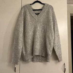 Grå stickad tröja från FB Sister - Mysig grå stickad tröja från FB Sister med v-ringning. Perfekt för kyliga dagar med sin mjuka och bekväma passform. Tröjan har långa ärmar och ribbade fina kanter☺️💓Tröjan passar XXS-S