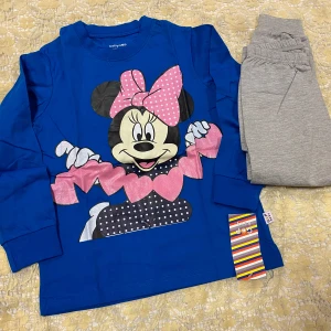 Barn Disney Kläder I 2 delar  - Söt blå långärmad tröja från babyGAP med ett stort Musse Pigg-motiv. Perfekt för små barn som älskar Disney. Tröjan är gjord i mjukt material och har en lekfull design med rosa och svarta detaljer. 100% bomull, 145kr/2 delar/ paket, finns 2-7 år kvar 