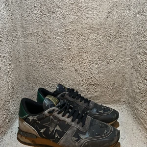Svarta sneakers med stjärndetaljer - Snygga svarta sneakers med stjärndetaljer och gröna inslag. Skorna har en robust sula och snörning framtill. Perfekta för en cool och avslappnad stil.