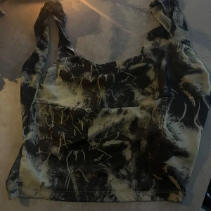 Mönstrad topp från Shein - Topp från Shein med mönster i svart och grön. Toppen har en knytning bak och breda axelband. 