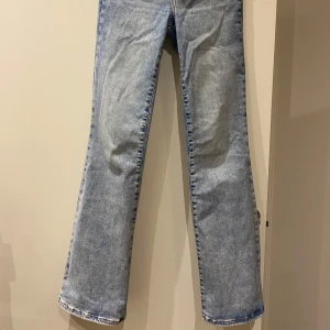 Blå bootcut jeans - Snygga blå högmidjade bootcut jeans i klassisk denimstil. De har en bekväm passform och är perfekta för en avslappnad look. Jeansens design inkluderar fem fickor.