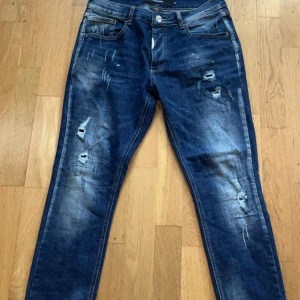 Blå jeans från Alessandro - Snygga blå jeans från Alessandro med slitna detaljer och en cool tvätt. Perfekta för en avslappnad stil.