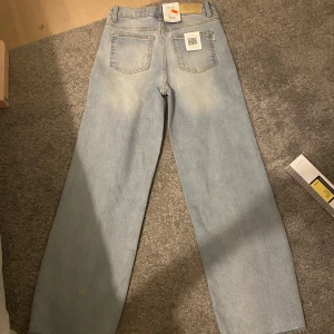 Ljusa jeansbyxor från Cubus  - Säljer ett par ljusa cubus jeans med en klassisk straight passform. Byxorna har en hög midja och är perfekta för en avslappnad stil. De har en traditionell femficksdesign och är tillverkade i slitstarkt denim.