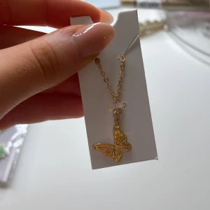 Guldigt fjärilshalsband - Sött halsband med justerbar längd. Aldrig använd och är fortfarande kvar i original förpackning, inga repor eller så💕