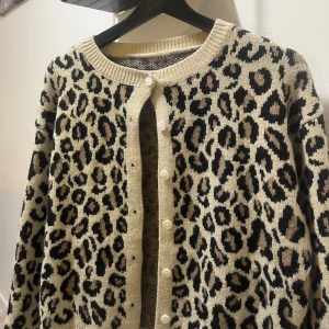Stickad Kofta - En stickad tröja/kofta med knappar i leopardmönster från Shein. Storlek S. Använd 2 gånger. Köpt för 186kr.
