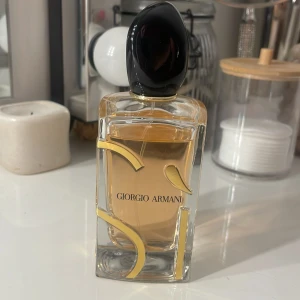 Giorgio Armani Si Eau de Parfum 100 ml - Elegant parfymflaska från Giorgio Armani med en stilren design. Flaskan är genomskinlig med gyllene detaljer och innehåller en varm, bärnstensfärgad doft.  Perfekt för den som söker en sofistikerad och tidlös doft. Säljare pga att doften inte passar mig.