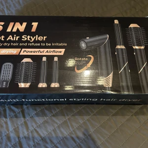 6 i 1 Hot Air Styler - Helt ny i orginalförpackning. Multifunktionell stylingverktyg med 6 olika tillbehör för att locka, räta ut, kamma och torka håret. Inkluderar en roterande funktion och kraftfull luftflöde. Perfekt för att skapa olika frisyrer med enkelhet.