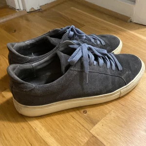 Grå sneakers - Snygga grå sneakers från Garment Project i mocka och cremevit sula. Använda men i fint skick