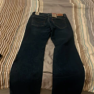 Mörkblå jeans från Levi's - Snygga mörkblå jeans från Levi's med klassisk femficksdesign och knappgylf. Perfekta för en avslappnad stil med en touch av vintagekänsla. Helt i nyskick och är perfekt nu i vintern. Som ni ser så finns det lappar kvar 
