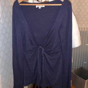 Mörkblå långärmad och urringad knyt-topp från design by si - Säljer en snygg marinblå topp från design by si i storlek xs/S. Den har långa ärmar och en knytning framtill som ger en fin detalj. Perfekt för både vardag och fest! 💙 köpt för 400 och är som ny⭐️