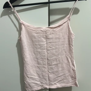 Ljusrosa linnetopp - Säljer en söt ljusrosa linnetopp i storlek XS. Perfekt för sommardagar eller som ett basplagg under en kofta. Toppen har smala axelband och är i ett mjukt material som känns skönt mot huden.