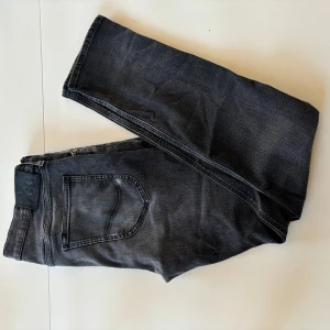 Lee Luke - Säljer ett par svarta jeans i bra skick. De har en snygg, lite sliten look. Jeansen har en slim passform och är tillverkade i ett bekvämt material som sitter bra hela dagen. Perfekta för höst och vinter! Storlek 34/32.