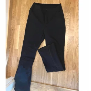 Skidbyxor Everest S/36 supersnygga på!! - Supersnygga svarta skidbyxor från Everest. Smal passform, sitter tajt över rumpa/ben och lite vidare nertill. Dragkedja i benslut. 86% polyester 14% elastan.  Knappt använda så ser nästintill oanvända ut.  Står ingen storlek men uppskattas till S/36. Midja ca 36cm Innerbenslängd ca 79cm