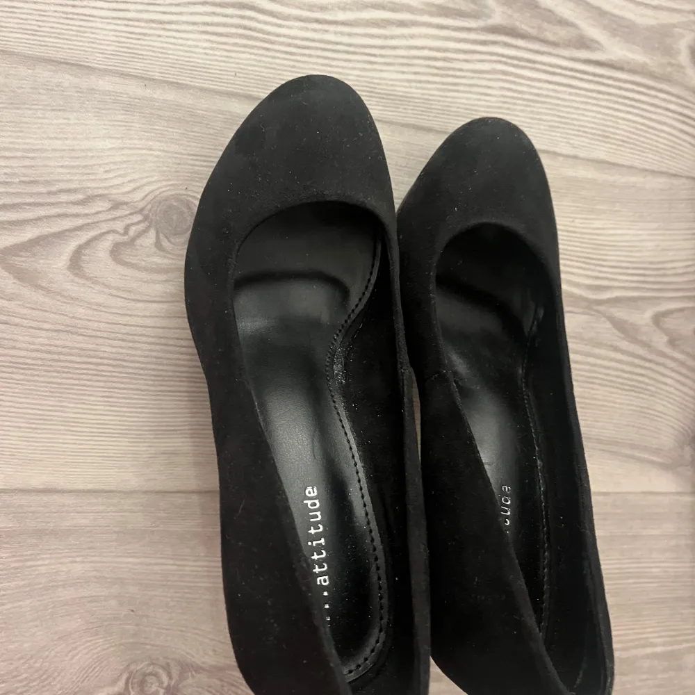 Säljer ett par eleganta svarta pumps från Attitude i storlek 36. De har en klassisk design med rund tå och en stabil klack, perfekta för både fest och vardag. Skorna är i mycket bra skick och har en bekväm passform. (Aldrig använda). Skor.