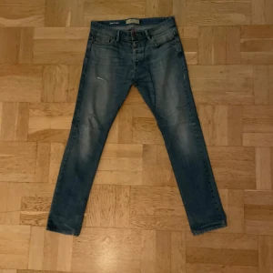 Next vintage jeans - Tjena, säljer ett par Next vintage jeans i blå färg. Skicket är 9/10 utan några defekter. De är fadeade och har en slitning, riktigt feta till vintern. Material är stretchigt och det sitter jätte bra längs benet. Skriv för mer bilder!