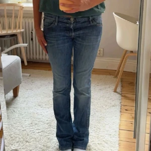 Blå bootcut jeans - Säljer ett par snygga blå bootcut jeans från replay. De är i bra skick doch har en liten hål (se sista bild). Midjemått är 41cm och innerbenslängden är 78cm