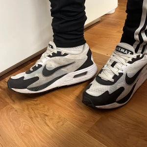 Nike Air Max sneakers i svart och vit - Säljer ett par Nike Air Max sneakers i svart och vit. De har en klassisk design med snörning och en bekväm sula. Perfekta för både vardag och träning. Skorna är i bra skick men använda.