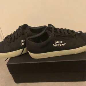 Saint Laurent Skor - Säljer ett par snygga svarta skor från Saint Laurent i bra skick. De har klassisk snörning och en vit sula som ger en stilren look. Perfekta för både vardag och fest! Kommer med originalförpackning.