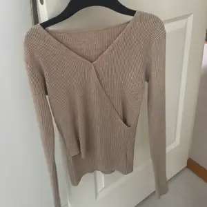 Säljer en superfin beige ribbad omlottopp med lång ärm. Perfekt för höst och vår, den är både stilren och bekväm. Passar till både vardag och fest! 💫