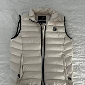 Dunväst Pelle P - Säljer en snygg beige dunväst från Pelle P i storlek L.  Västen är använd 10 gånger och är i perfekt skick. 10/10