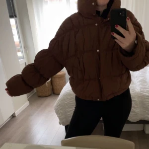 Brun pufferjacka - Säljer en mysig brun pufferjacka i bra skick. Från NA-KD med puffärmar