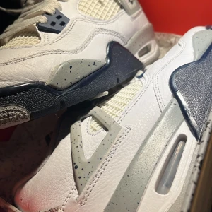 Nike Air Jordans 4 Midnight navy med blå, vit och grå design - Säljer ett par snygga Nike Air Jordans 4 midnight navys. Skorna har en cool design av blå, vit och grå. Dom är använda ungefär 5 gånger.  Dessa. skor är perfekta för både vardag, fest sport osv.