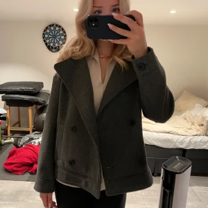 Grå kappa från Stradivarius - Säljer en snygg grå kappa från Stradivarius i storlek S. Jackan är i mycket bra skick och har långa ärmar. Perfekt för att hålla stilen när det blir lite kyligare ute! Extra knappar tillkommer!❤️