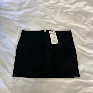 Svart kjol från Zara - Snygg kort kjol från Zara. 🌸 Helt oanvänd, prislappen kvar. Perfekt för både vardag och fest! Passar bra nu inför jul och nyår 🎄