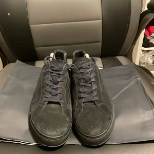 Svarta sneakers från Tommy Hilfiger - Snygga mörk blå sneakers i mocka från Tommy Hilfiger. De har en klassisk design med snörning och en diskret logga på hälen. Perfekta för både vardag och fest. Skorna är i mycket bra skick och redo för nya äventyr!