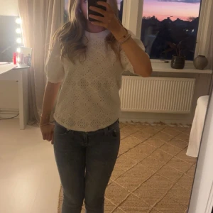 Vit blus med spetsdetaljer - Säljer en superfin vit blus med spetsdetaljer. Den har korta ärmar och ett vackert mönster som ger en romantisk känsla. Perfekt för både vardag och fest!  💗💕