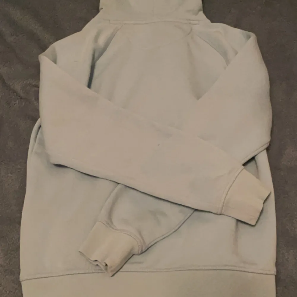 Säljer en snygg ljusblå hoodie från GANT med deras klassiska logga och ett coolt emblem på bröstet. Perfekt för både vardag och chill. Den är i bra skick och supermjuk. Passar perfekt för höst och vår. 🧢. Neuletakit & Villapaidat.
