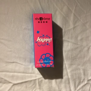 RévArôme Neon Happy Eau de Parfum - Säljer en supercool parfym från RévArôme som heter Neon Happy. Flaskan är i en snygg gradient av blått och rosa, vilket ger en riktigt poppig och glad känsla. Den rymmer 50 ml och är perfekt för dig som vill ha en doft som sticker ut. Perfekt för både vardag och fest!