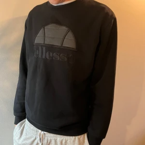 Sweatshirt Ellesse stl S (rymlig) - Sweatshirt från Ellesse i fint skick. Svart. Material 76 % bomull och 26 % polyester. Stl S men rätt stor. Modellen på bilden är cirka 193 cm. 