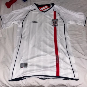 Retro England 2002 tröja - Hej! Jag säljer en England tröja från 2002. Med ingen på baksidan. Helt ny med tag. Säljer för 340. Var tyvärr för stor på mig. Skriv om frågor. Pris kan diskuteras