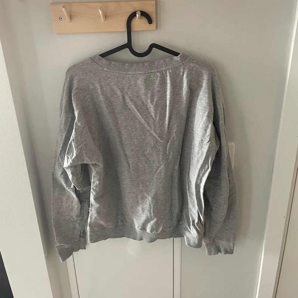 Säljer en grå sweatshirt från Adidas Originals. Tröjan är långärmad och gjord i ett mjukt bomullsmaterial, perfekt för en avslappnad stil. Den är använd men fortfarande i väldigt fint skick. . Tröjor & Koftor.