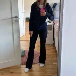 Säljer en snygg mörkblå hoodie från Nike med dragkedja och huva. Den har ett diskret mönster och Nike-loggan broderad på bröstet. Perfekt för en avslappnad stil!