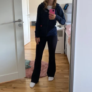 Mörkblå hoodie från Nike - Säljer en snygg mörkblå hoodie från Nike med dragkedja och huva. Den har ett diskret mönster och Nike-loggan broderad på bröstet. Perfekt för en avslappnad stil!